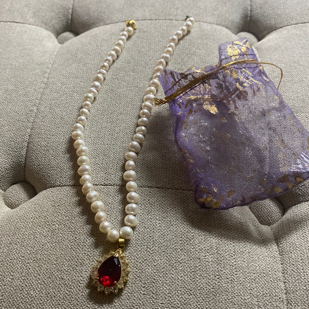 Children’s necklace pearl Disney with a purple bag .